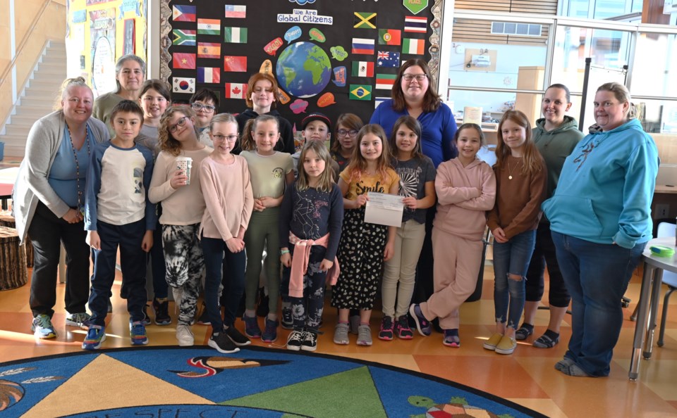 Students with Ma Murray school's EarlyAct club leadership program presenting a $700 cheque to the Meals on Wheels program Wednesday afternoon. Nov. 9, 2022. (Dave Lueneberg/Alaska Highway News)